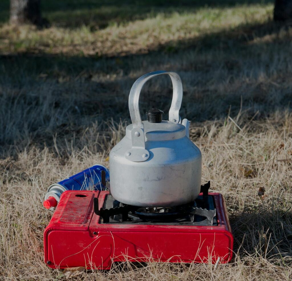 a kettle over a portable stove camping gas canister