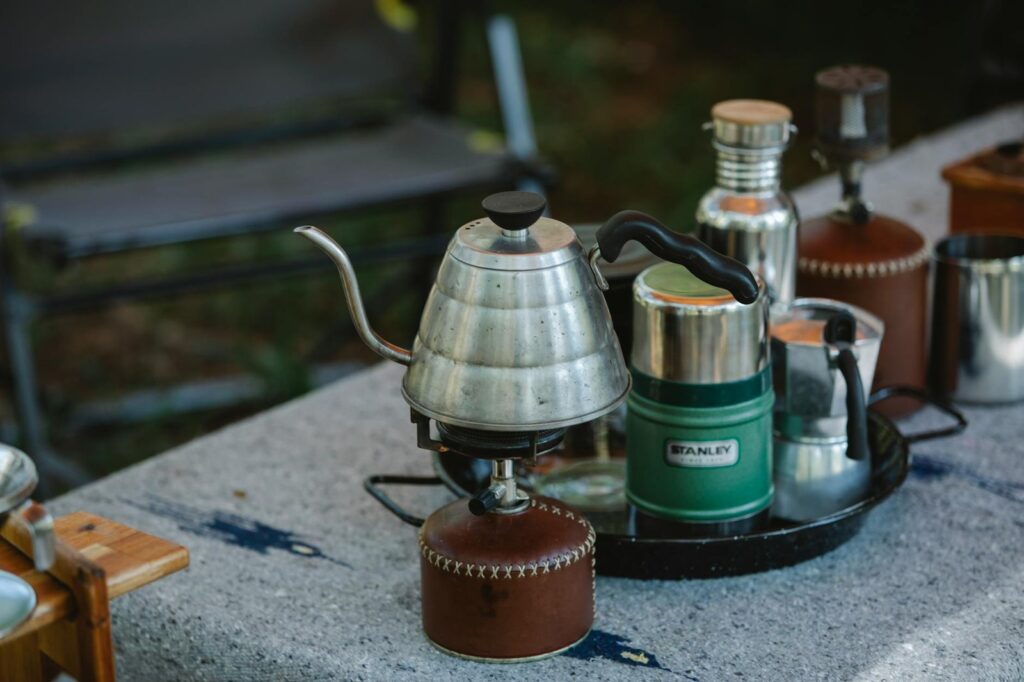 coffee kettle on gas stove placed on table during camping